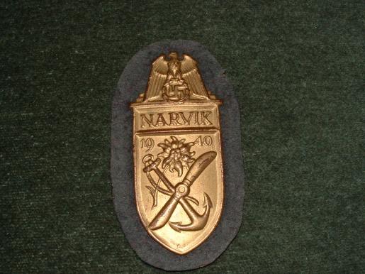 NEAR MINT NARVIK SHEILD IN GILT WITH FULL BACKING.